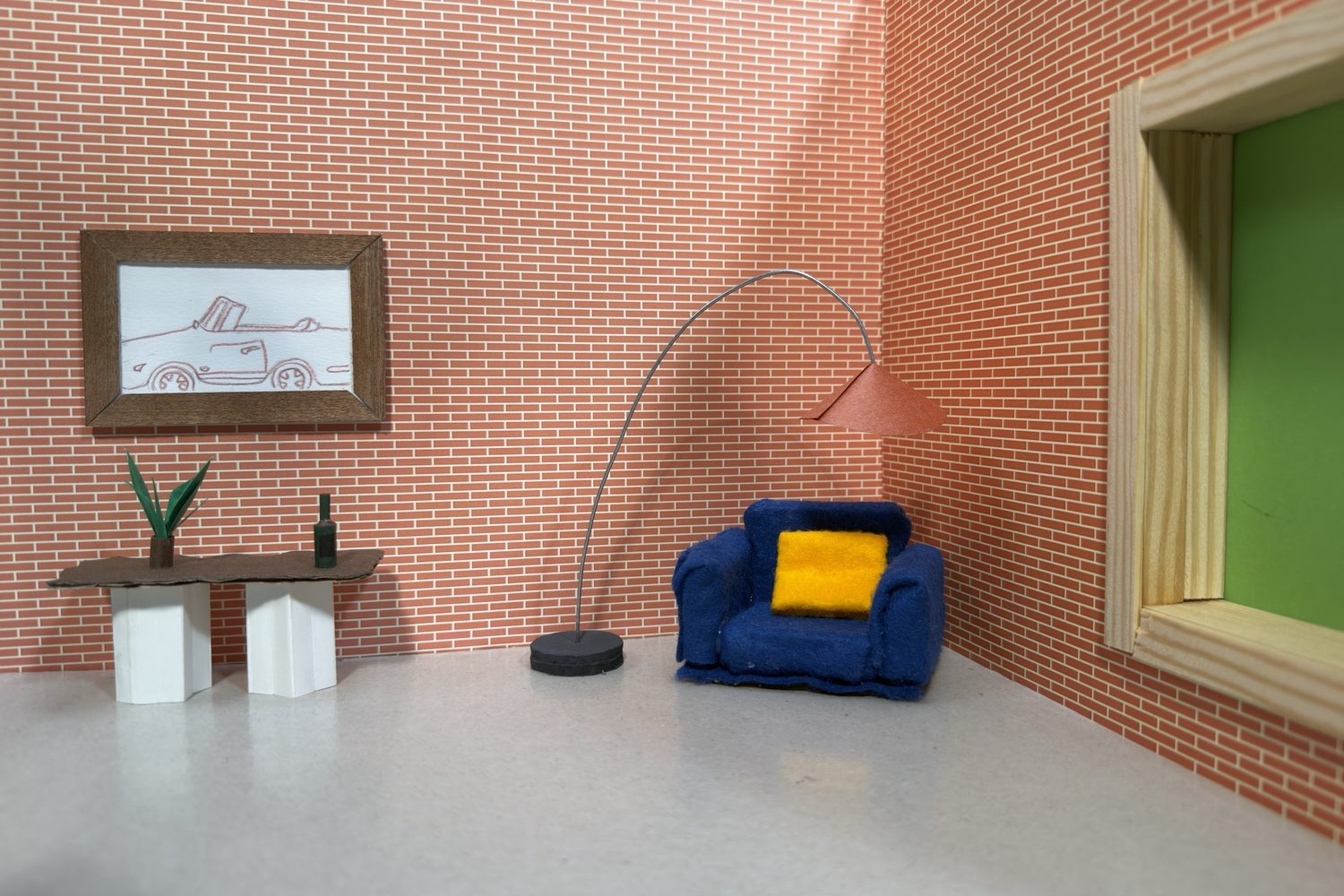 Close-up of the brick wall with a framed drawing of a car, a small table with a plant, an arched lamp, a blue armchair with a yellow cushion and a window with a green view.