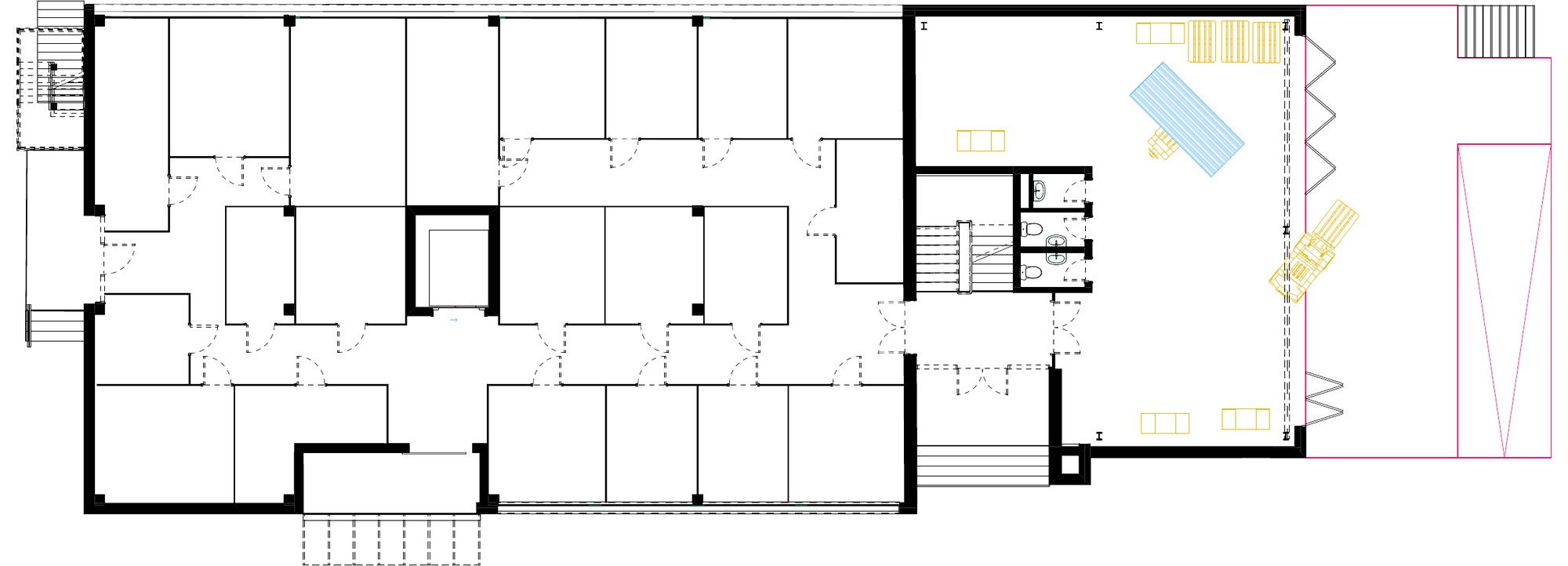 Plan of the first floor: a long block of storage cells with corridors on the left and a workshop hall with a pool-like blue table on the right.